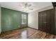 Bedroom with wood floors, ceiling fan, closet, and green accent wall at 1047 Holt Rd., Conway, SC 29526