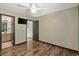 Bedroom featuring wood floors, ceiling fan, view into bath and living room, closet, and television at 1047 Holt Rd., Conway, SC 29526