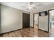 Bedroom featuring wood floors, ceiling fan, view into bathroom, closet, and television at 1047 Holt Rd., Conway, SC 29526