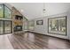 Open living room featuring a stone fireplace, wood floors, vaulted ceiling, and large windows for ample natural light at 1047 Holt Rd., Conway, SC 29526