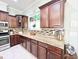 A kitchen features granite countertops, mosaic backsplash, dark wood cabinets, and stainless appliances at 1652 Murrell Pl., Murrells Inlet, SC 29576