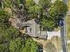 Aerial view of a home with mature trees, a long driveway, and a well-maintained roof at 2 Sunrise Ct., Carolina Shores, NC 28467