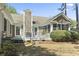 Home's back exterior features a back deck, screened-in porch, brick chimney, and well-manicured lawn at 2 Sunrise Ct., Carolina Shores, NC 28467