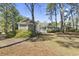 Back exterior of home features screened in porch, back porch, mature landscaping and trees at 2 Sunrise Ct., Carolina Shores, NC 28467