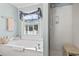 Bathroom featuring garden tub with window, patterned curtain, and shower with bench at 2 Sunrise Ct., Carolina Shores, NC 28467