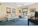 Well-lit bedroom with blue carpet, vibrant couch, and vintage airplane decor at 2 Sunrise Ct., Carolina Shores, NC 28467