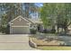 Charming single-story home with neutral siding, mature trees, and an attached two-car garage at 2 Sunrise Ct., Carolina Shores, NC 28467