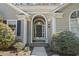 Charming home front door with arched entryway, decorative plants, and stone pathway at 2 Sunrise Ct., Carolina Shores, NC 28467