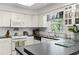Full kitchen view with stainless steel sink, white cabinets, and laminate wood flooring at 2 Sunrise Ct., Carolina Shores, NC 28467