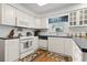 Functional kitchen with white appliances, black counters, and bright natural light at 2 Sunrise Ct., Carolina Shores, NC 28467