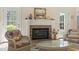 Cozy living room with brick fireplace, neutral walls, and French doors to the exterior at 2 Sunrise Ct., Carolina Shores, NC 28467