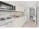 Well-lit kitchen featuring white cabinetry, a microwave, sink, stove, and refrigerator at 2001 S Ocean Blvd. # 720, Myrtle Beach, SC 29577