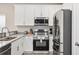 Kitchen with stainless steel appliances, white cabinets, and modern fixtures at 201-E Madison Ct., Myrtle Beach, SC 29577
