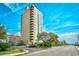 A high-rise condominium building is surrounded by lush landscaping and a parking lot at 210 75Th Ave. N # 4034, Myrtle Beach, SC 29572