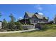 Gray home exterior featuring a covered porch, manicured shrubs, and a retaining wall at 216 Kinross Ct., Little River, SC 29566