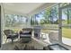 Screened porch with outdoor seating overlooking the tranquil backyard at 216 Kinross Ct., Little River, SC 29566