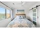 Cozy bedroom with barn door, decorative bedding, and a window view at 2710 S Ocean Blvd. # 407-A, Myrtle Beach, SC 29577