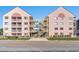 Exterior view of condo buildings with access stairs and walkway over the driveway at 2710 S Ocean Blvd. # 407-A, Myrtle Beach, SC 29577