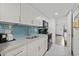 Well-lit kitchenette with sleek, white cabinets, stainless steel sink, and modern appliances at 3000 N Ocean Blvd. # 130, Myrtle Beach, SC 29577