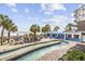 Exterior view of the pools and lounge area with palm trees and beach views at 3000 N Ocean Blvd. # 130, Myrtle Beach, SC 29577