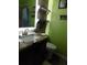Cozy bathroom with a granite countertop vanity, wood shelves and a toilet with green walls at 305 N Hillside Dr. N # 103, North Myrtle Beach, SC 29582