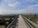 A wooden boardwalk leads to the beach with ocean views at 305 N Hillside Dr. N # 103, North Myrtle Beach, SC 29582