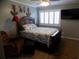 Cozy bedroom with a decorative quilt, plantation shutters, a ceiling fan and a mounted television at 305 N Hillside Dr. N # 103, North Myrtle Beach, SC 29582