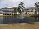 Serene view of the building overlooking the pond with a water fountain at 305 N Hillside Dr. N # 103, North Myrtle Beach, SC 29582