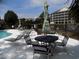 Poolside with lounge chairs, umbrellas, and buildings at 305 N Hillside Dr. N # 103, North Myrtle Beach, SC 29582