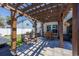Inviting back patio with a wooden pergola, swing, dining table, and string lights at 318 Board Landing Circle, Conway, SC 29526