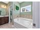 Bright bathroom with a soaking tub, tile accents, and a window for natural light and ventilation at 318 Board Landing Circle, Conway, SC 29526