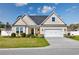 Charming one-story home with manicured lawn, tidy landscaping, and a two-car garage on a sunny day at 318 Board Landing Circle, Conway, SC 29526