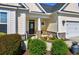 Inviting front porch with stone accents, rocking chairs, and lush landscaping details create instant curb appeal at 318 Board Landing Circle, Conway, SC 29526