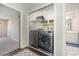 Laundry closet equipped with modern washer and dryer units, convenient shelving, and a view of the bathroom at 3704 Chapel Ln., Myrtle Beach, SC 29588
