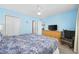Bedroom with blue walls, ceiling fan, dresser with a television, and a comfortable rocking chair at 412 Seaside Dr. S, Surfside Beach, SC 29575