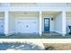 Exterior view of a well-maintained townhome, showcasing a garage, front door, and tidy landscaping for a welcoming appeal at 4850 Cantor Ct. # 202, North Myrtle Beach, SC 29582