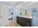 Bright bathroom with a double sink vanity, tile flooring, and an open doorway to the bedroom at 510 S Ocean Blvd., Surfside Beach, SC 29575