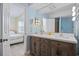 Bathroom featuring double sink vanity, large mirror, and open doorway to a bedroom at 510 S Ocean Blvd., Surfside Beach, SC 29575