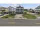 Charming three-story beach house with white railings, set on a lot with well-kept lawn on a sunny day at 510 S Ocean Blvd., Surfside Beach, SC 29575