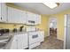 Bright kitchen featuring white cabinets and views to a dining area at 510 S Ocean Blvd., Surfside Beach, SC 29575
