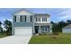 Charming two-story home with blue siding, white garage door, and well-maintained front yard at 5152 Yellowstone Dr., Conway, SC 29526