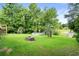 Expansive backyard with lush green lawn, fire pit, convenient storage shed, and serene pond access at 532 Medcalf Dr. Sw, Sunset Beach, NC 28468