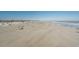 Expansive beach with people enjoying the sun and surf, featuring clear skies and calm waters at 532 Medcalf Dr. Sw, Sunset Beach, NC 28468