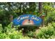 Community sign for Sunset Lakes surrounded by green foliage and colorful flowers at 532 Medcalf Dr. Sw, Sunset Beach, NC 28468