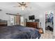 Relaxing main bedroom boasts modern ceiling fan, dresser, and walk-in closet at 532 Medcalf Dr. Sw, Sunset Beach, NC 28468