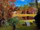 Picturesque pond surrounded by colorful foliage, reflecting the sky and trees, with a small dock at 532 Medcalf Dr. Sw, Sunset Beach, NC 28468