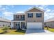 Charming two-story home with a two-car garage, a covered front porch, and low-maintenance landscaping at 555 Firouz Dr, Longs, SC 29568