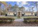 Charming single-story home with a yellow exterior, black front door, and a circular driveway at 5825 Peachtree Rd., Myrtle Beach, SC 29588
