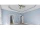 Neutral bedroom with tray ceiling, ceiling fan, and view to hallway and bathroom at 615 Woodbine Ct., Myrtle Beach, SC 29579