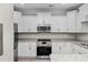 This spacious kitchen features white cabinets, granite countertops, and stainless steel appliances at 627 Bonaventure Dr. # 103, Myrtle Beach, SC 29577